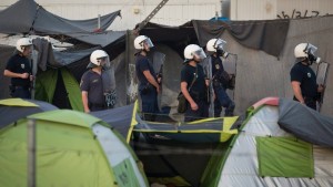 Követ dobáló bevándorlókkal állnak szemben görög rendőrök. (MTI/AP/Darko Bandic)